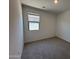 Bright bedroom featuring neutral carpet, white walls and a window allowing ample natural light at 46886 W Old Timer Rd, Maricopa, AZ 85139