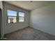 Bright bedroom featuring neutral carpet, white walls and large windows allowing ample natural light at 46886 W Old Timer Rd, Maricopa, AZ 85139