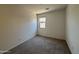 Bright bedroom featuring a window, neutral walls, and plush gray carpeting at 46886 W Old Timer Rd, Maricopa, AZ 85139