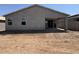 Rear exterior view of the home featuring a covered patio area and symmetrical window placement at 46886 W Old Timer Rd, Maricopa, AZ 85139