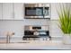 Close-up of kitchen with stainless steel range, microwave, and sleek backsplash at 475 S Soho Ln # 35, Chandler, AZ 85225