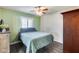 Cozy bedroom featuring a ceiling fan, shuttered window, and stylish dark wood floors at 5915 E Fairfield St, Mesa, AZ 85205