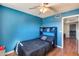 Cozy bedroom features blue walls, a ceiling fan, and a window for natural light at 5915 E Fairfield St, Mesa, AZ 85205