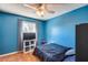 Cozy bedroom features blue walls, a ceiling fan, and a window for natural light at 5915 E Fairfield St, Mesa, AZ 85205