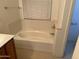 Bathroom featuring a white tub and tile surround at 614 W 7Th Ave, Mesa, AZ 85210