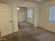 Bedroom featuring carpeted floors, neutral walls, a ceiling fan, and a mirrored sliding closet door at 614 W 7Th Ave, Mesa, AZ 85210