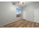 Bright bedroom featuring modern light fixtures, wood-look flooring, and a large window with a view at 6993 S Roger Way, Chandler, AZ 85249