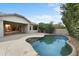 Tranquil backyard with a sparkling pool, lush greenery, and outdoor seating area for relaxation at 6993 S Roger Way, Chandler, AZ 85249