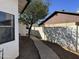 A side view of a backyard featuring a stone pathway and privacy wall at 7350 E Pueblo Ave, Mesa, AZ 85208