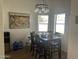 Cozy dining area with a dark wood table, seating for six, a modern light fixture, and natural light at 7350 E Pueblo Ave, Mesa, AZ 85208