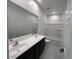 Well-lit bathroom featuring a double vanity, large mirror, and a bathtub with a shower at 7418 W Rovey Ave, Glendale, AZ 85303