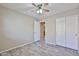 Neutral bedroom with wood-look flooring, a ceiling fan, and closet access at 7642 W Carlota Ln, Peoria, AZ 85383