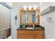 Clean bathroom with granite countertop vanity and a large framed mirror at 7912 E Plaza Ave, Scottsdale, AZ 85250