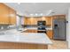 Modern kitchen with stainless steel appliances, light wood cabinets, and white quartz countertops at 7912 E Plaza Ave, Scottsdale, AZ 85250