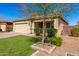 Attractive single-story home with lush lawn, mature landscaping, and brick-paved driveway at 828 W Leadwood Ave, San Tan Valley, AZ 85140