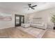 Bright living room featuring wood floors, a ceiling fan, and a comfortable sectional sofa at 828 W Leadwood Ave, San Tan Valley, AZ 85140