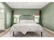 Stylish main bedroom with olive green accent wall, two windows, and ensuite bathroom at 828 W Leadwood Ave, San Tan Valley, AZ 85140