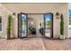 View from the backyard into the home, featuring french doors, sleek outdoor lighting, and lush green trees at 8315 N Sendero Tres M --, Paradise Valley, AZ 85253