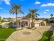 Stunning home with manicured landscaping, circular driveway, and stately palm trees under a blue sky at 8315 N Sendero Tres M --, Paradise Valley, AZ 85253