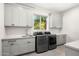 Modern laundry room with gray cabinets, countertop, and stainless steel washer and dryer at 8315 N Sendero Tres M --, Paradise Valley, AZ 85253