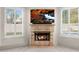 Bright living room featuring a stone fireplace, mounted TV, and plantation shutters on the windows at 8315 N Sendero Tres M --, Paradise Valley, AZ 85253