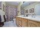 Well-lit bathroom with double sink vanity and patterned shower curtain at 835 W Beechnut Dr, Chandler, AZ 85248