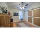 Bedroom with barn door, ceiling fan, and a television for relaxing entertainment at 835 W Beechnut Dr, Chandler, AZ 85248