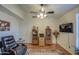 Cozy living room with a comfortable leather chair, ceiling fan, and built-in bookshelves for storage at 835 W Beechnut Dr, Chandler, AZ 85248