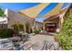 Inviting backyard patio with shade canopies, comfortable swing, and colorful potted plants at 855 E Vaughn Ave, Gilbert, AZ 85234