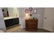 Bedroom featuring wooden dresser with decorative items on top, adjacent to a bathroom with black cabinets at 855 E Vaughn Ave, Gilbert, AZ 85234