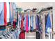 A walk in closet with an abundance of clothing hung on the rods and shoes and bags on the shelves at 855 E Vaughn Ave, Gilbert, AZ 85234