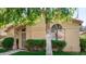 Single-story home with arched windows, green lawn and neat landscaping framed by mature tree at 855 E Vaughn Ave, Gilbert, AZ 85234