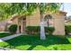 Single-story home with well-maintained lawn, arched windows and entryway framed by lush trees at 855 E Vaughn Ave, Gilbert, AZ 85234