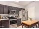 Well-lit kitchen featuring stainless steel appliances, dark cabinetry, a center island, and light countertops at 855 E Vaughn Ave, Gilbert, AZ 85234