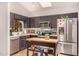 A kitchen featuring stainless appliances, dark cabinets, island, and a view out the window at 855 E Vaughn Ave, Gilbert, AZ 85234