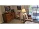 Cozy living room featuring a plush armchair, wooden dresser with decorative items, and ample natural light at 855 E Vaughn Ave, Gilbert, AZ 85234