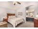 Bedroom with a view of the ensuite bath, neutral walls, ceiling fan, and a floral quilt on the bed at 855 E Vaughn Ave, Gilbert, AZ 85234