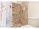 Tile shower in a bathroom with a floral shower curtain, grab bar, and toiletry shelf at 855 E Vaughn Ave, Gilbert, AZ 85234