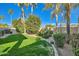 Spacious backyard featuring a well-maintained lawn, mature trees, and decorative rock landscaping at 8632 E Gail Rd, Scottsdale, AZ 85260