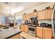 Functional kitchen space with stainless steel appliances, light wood cabinets, and casual dining area at 8632 E Gail Rd, Scottsdale, AZ 85260