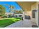 Covered patio featuring a lush lawn, decorative brick pavers, and a built-in barbecue area at 8632 E Gail Rd, Scottsdale, AZ 85260