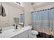 Well-lit bathroom features a white vanity, large mirror, and a shower-tub combination with curtain at 9019 W Acoma Dr, Peoria, AZ 85381