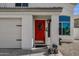 A bright red front door welcomes visitors to this charming home with an attached two car garage at 9019 W Acoma Dr, Peoria, AZ 85381