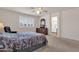 Bright bedroom with shutters, ceiling fan, carpet, and an en-suite bathroom at 9019 W Acoma Dr, Peoria, AZ 85381