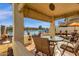 Covered patio overlooking a tranquil waterfront view with a table and chairs at 9019 W Acoma Dr, Peoria, AZ 85381