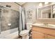 Full bathroom with gray tiled shower, light wood vanity, and decorative shelves at 9031 N 14Th St, Phoenix, AZ 85020