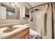 Cozy bathroom featuring a shower, wood vanity, decorative cabinet and earth-tone color palette at 9031 N 14Th St, Phoenix, AZ 85020