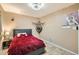 Bedroom features a plush red bedspread, a gray upholstered headboard, neutral walls, and ceiling fan at 9031 N 14Th St, Phoenix, AZ 85020