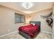 Inviting bedroom with a plush red bedspread, neutral walls, and a cozy ambiance at 9031 N 14Th St, Phoenix, AZ 85020