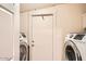 Functional laundry room featuring a washer and dryer, utility sink, and storage cabinets at 9031 N 14Th St, Phoenix, AZ 85020